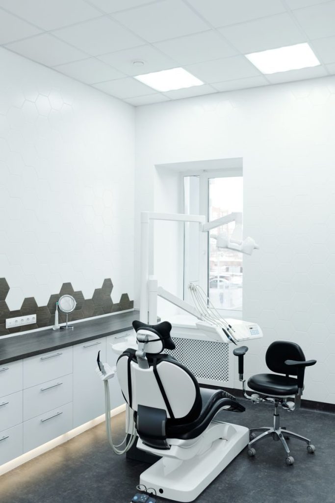 A bright, clean dental clinic showcasing a modern dental chair and equipment.